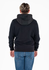 Felpa nera con cappuccio a contrasto nero, polsini e vita a costine. La vista dal retro mostra una superficie liscia e i dettagli delle cuciture delle spalle. Visibili jeans blu.