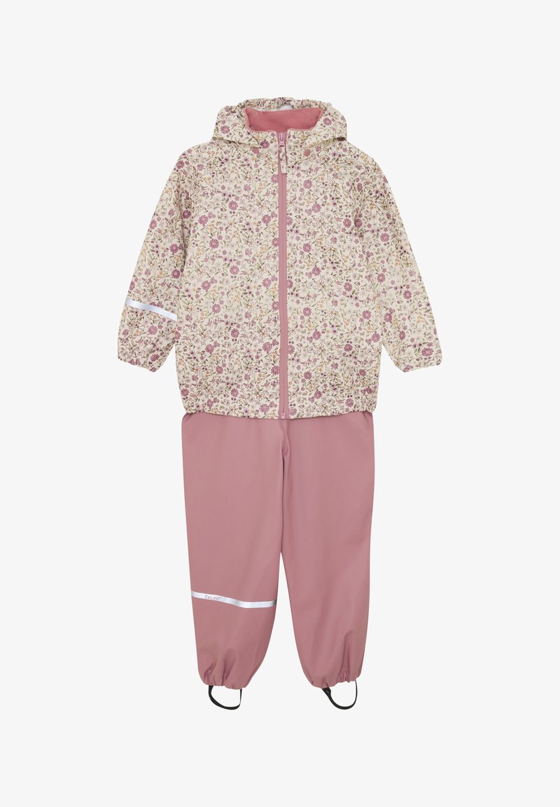 Impermeabile con stampa floreale color crema, abbinato a pantaloni impermeabili rosa con polsini elastici e dettagli riflettenti.