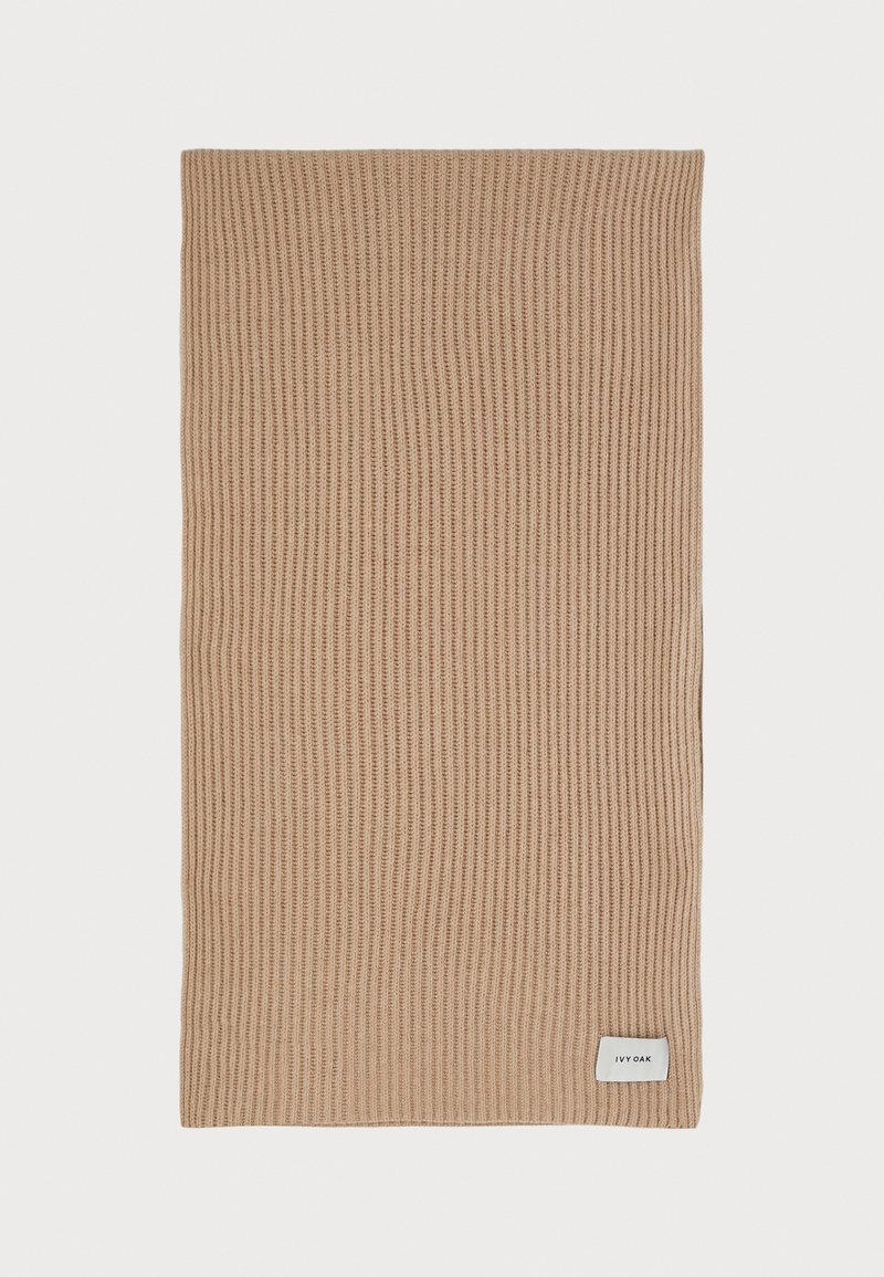Beige kootud sall vertikaalse soonikuga, millel on alumises paremases nurgas väike valge silt "IVY OAK". Pehme tekstuur, ristkülikukujuline vorm.