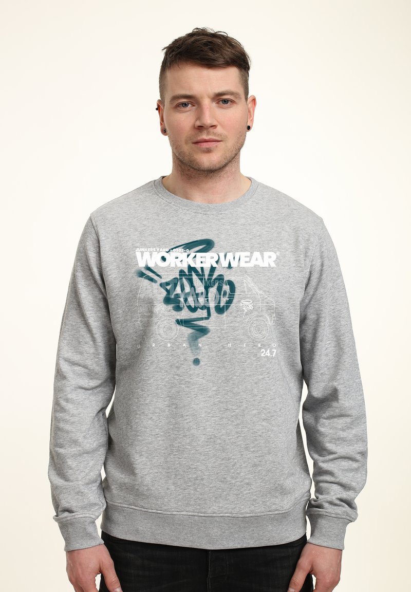 Šedá mikina s dlouhými rukávy a kulatým výstřihem, s grafickým potiskem označeným "WORKERWEAR" v bílé a tyrkysové barvě. Měkká textura.