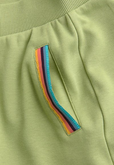 Hellgrüner Joggingstoff mit einem elastischen Bund. Verfügt über eine Seitenasche mit einem mehrfarbigen gestreiften Akzent in Türkis, Pink und Gelb.