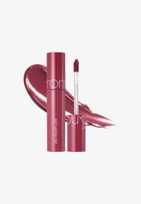 Tumma vaaleanpunainen huulitippa pyöreässä putkessa, jossa on valkoista tekstiä. Mukana kirkas aplikaattori, jossa on pehmeä, karvainen kärki. Kiiltävä väri taustalla.