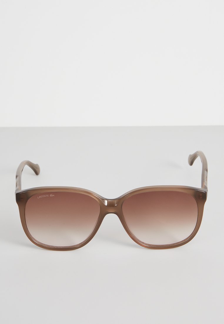 Lunettes de soleil dégradées marron avec une monture rectangulaire arrondie, en plastique lisse, et un branding subtil sur la branche.