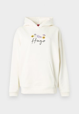 Crèmekleurige hoodie met een voorzak, voorzien van een bloemmotief en de tekst "Hugo" in cursief, gemaakt van zacht materiaal.