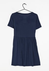 Tyrkysově modré šaty vyrobené z jemné tkaniny, s krátkými rukávy, nařaseným pasem a jednoduchým kulatým výstřihem. Visí na černém háčku.