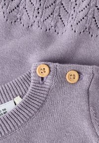 Pull tricoté violet clair avec un motif décoratif de feuilles en haut et des boutons en bois sur l'épaule gauche. Texture douce et col côtelé.