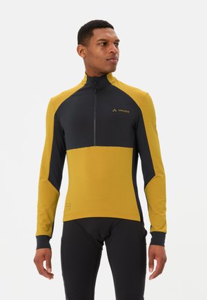 Hochgeschlossenes Fahrradtrikot mit gelbem Oberteil und schwarzem Unterteil. Hergestellt aus dehnbarem Stoff, mit einem halben Reißverschluss vorne und dezentem Logodesign.