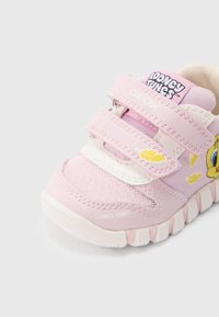 Sapatilha rosa para criança, com parte superior em malha, duas tiras de Velcro e personagem dos Looney Tunes bordado. Sola em borracha branca com detalhes texturizados.