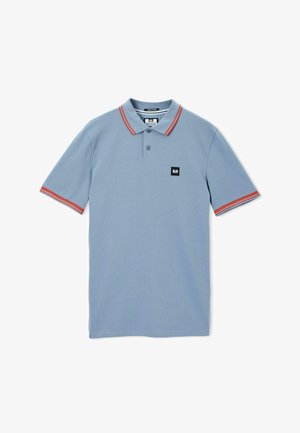 Jasnoniebieska koszulka polo z krótkim rękawem, z czerwono-białymi paskami na kołnierzyku i mankietach, z guziczkami na plastrze oraz małą czarną naszywką z logo na klatce piersiowej.