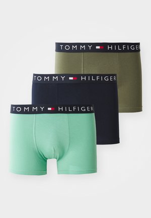 Tre par boksershorts i grønn, marineblå og oliven, hver med en svart midjebånd med "TOMMY HILFIGER"-logo og fargede aksenter.