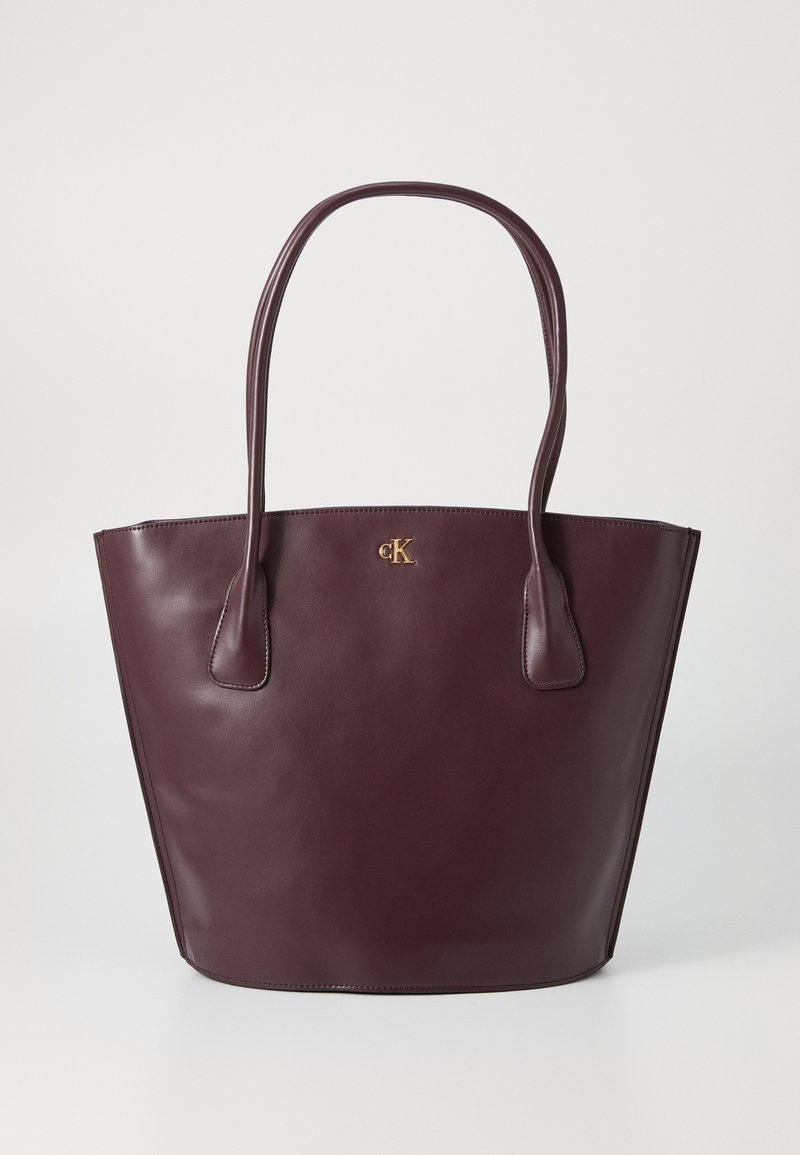 Burgundy leather tote bag, structured design, dual handles, embossed gold logo on front, smooth texture, open top for easy access.