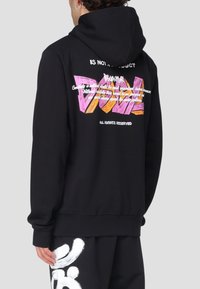 Felpa nera con cappuccio, caratterizzata da un graffito colorato sul retro, con vestibilità rilassata e maniche lunghe. Realizzata in cotone misto, ha una texture morbida.