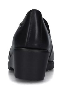 Scarpa con tacco a trapezio in pelle nera con una texture liscia, punta arrotondata e un tacco basso e spesso. Presenta cuciture minime e una finitura lucida.