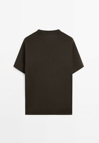 T-shirt a maniche corte con scollatura tonda in cotone marrone scuro. Presenta una schiena semplice con una vestibilità rilassata e orlo dritto.