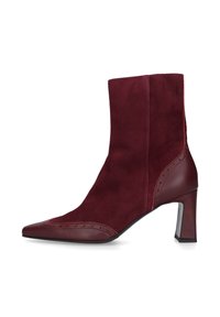 Stivaletto bordeaux realizzato in suede con punta affusolata, dettagli cuciti e tacco quadrato di tre pollici. Accenti in pelle liscia sui lati.