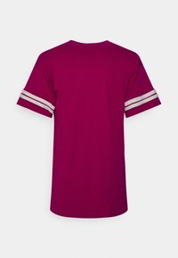 Krátké magenta tričko s krátkými rukávy, s šedými pruhy na rukávech. Vyrobeno z hladkého, lehkého bavlněného materiálu.