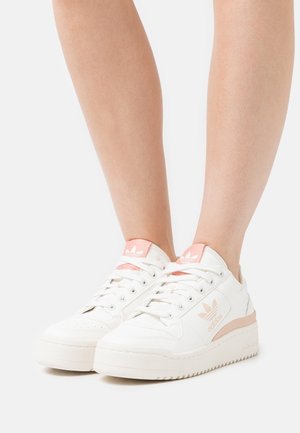 Valkoiset nahkaiset lenkkarit vaaleanpunaisin yksityiskohdin, pyöreä kärki, nauhallinen malli ja kuvioitu pohja. Sivulla ja kannassa kohokuvioitu logo.