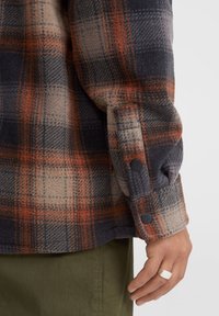 Flannel skjorte med et ternet mønster i orange, grå og beige nuancer. Knapmanchetter, blød tekstur og afslappet pasform.