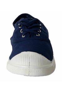 Zapatillas de lona azul marino con punta y suela de goma blanca. Presenta cuatro ojales metálicos con cordones a juego y suela blanca texturizada.