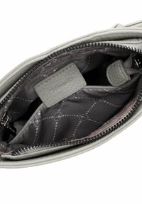 Interno di una borsa in pelle grigia chiara con una superficie liscia, caratterizzato da una fodera grigia a motivo e una piccola etichetta con testo in rilievo.