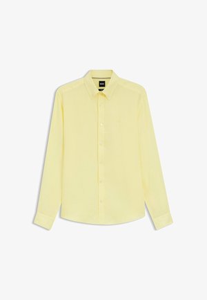 Heren overhemd met lange mouwen in lichtgeel, met knopen en kraag, voorzien van subtiel merkembleem op de borst, plat gelegd op een witte achtergrond.