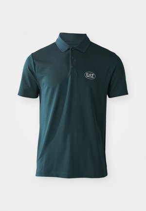 Tamnozelena polo majica s kratkim rukavima, dugmadi i bijelim EA7 Emporio Armani logom na lijevoj strani grudi, na bijeloj pozadini.