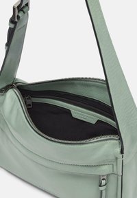 Borsa a spalla in pelle verde con una texture liscia, chiusura con zip e fodera in tessuto nero. Presenta un'etichetta con il marchio e una tracolla regolabile.