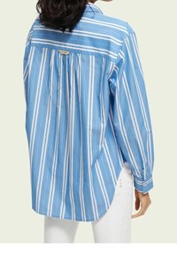 Blue and white striped long-sleeve shirt with a relaxed fit, featuring a buttoned collar and gathered back detail. Tailored cuffs.