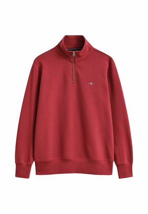 Red long-sleeve pullover with a quarter zip and small embroidered logo on the left chest, featuring ribbed cuffs and hem.