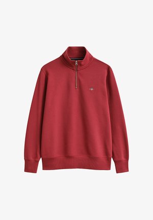 Red long-sleeve pullover with a quarter zip and small embroidered logo on the left chest, featuring ribbed cuffs and hem.