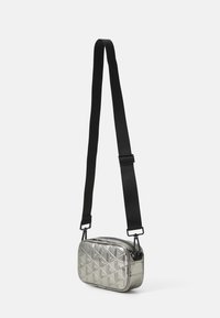 Borsa mini crossbody in argento metallico con motivo a rombi trapuntato, tracolla nera regolabile e chiusura con zip. Forma rettangolare e design elegante.