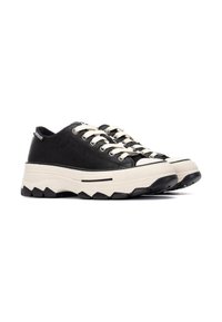 Zapatillas negras con una gruesa suela blanca de plataforma, punta redondeada, cordones blancos y detalles texturizados. Presenta una franja de acento negra en la suela.
