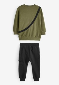 Oliven Grøn sweatshirt med sort buet stribe og ribbede manchetter, parret med sorte joggerbukser med sidelommer og elastisk talje.