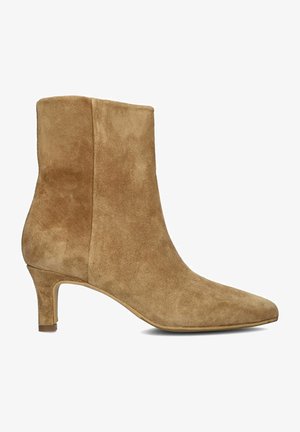Stivale alla caviglia in suede beige con punta affusolata e tacco di 6,5 cm. Texture liscia con cuciture a contrasto lungo il lato.