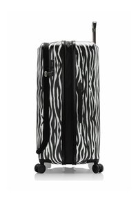 Maleta de concha dura a rayas en blanco y negro, con doble cremallera, asa telescópica y cuatro ruedas giratorias para una fácil maniobrabilidad.