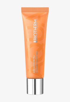 Tube orange avec un capuchon argenté, arborant le texte "BIOTHERM AQUASOURCE+ VITAMIN GLOW GEL" en police gras, surface lisse pour une prise en main facile.
