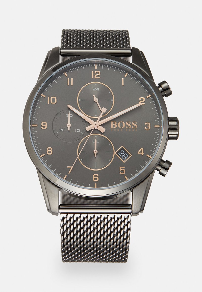 Montre chronographe avec un bracelet en acier inoxydable maillé noir, cadran gris foncé, index d'heure dorés, et affichage de la date à 6 heures.