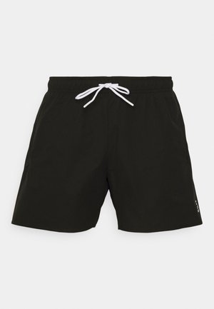 Sorte svømmeshorts med snor i taljen, laget av lett stoff. Har side lommer og en logo diskret trykt på benet.