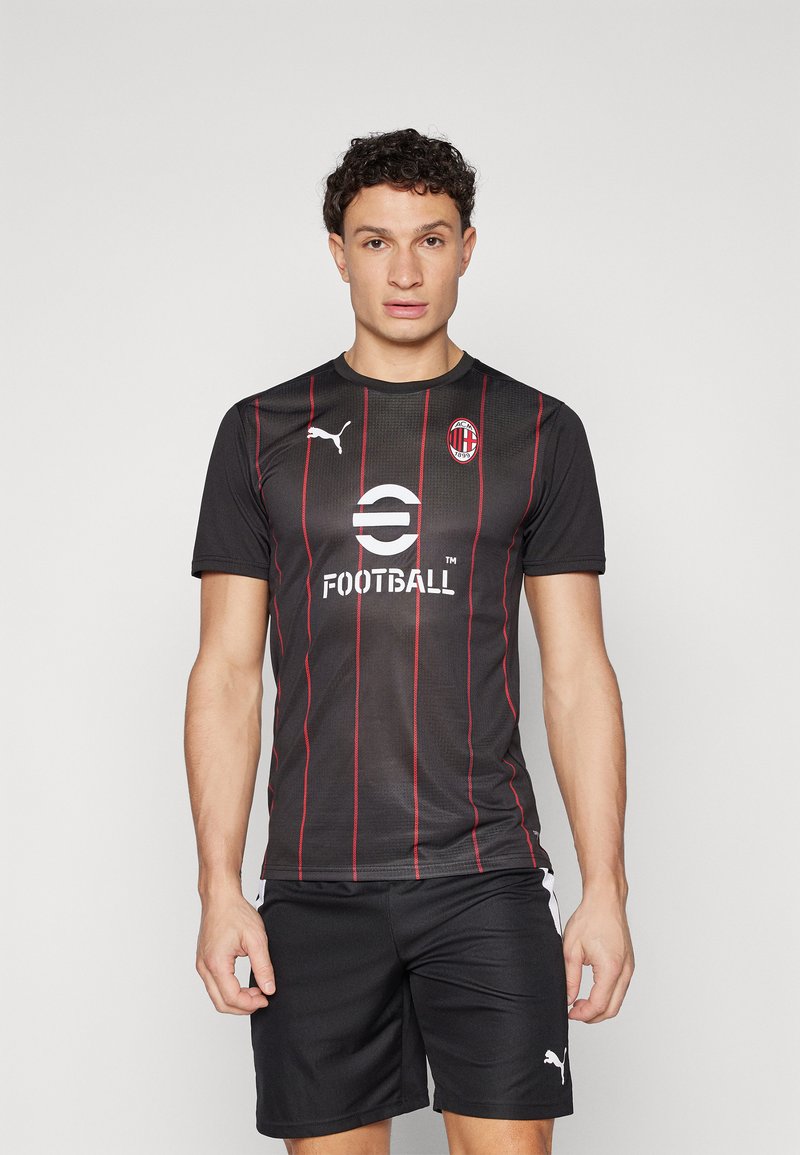 Čierne futbalové tričko s krátkym rukávom a červenými vertikálnymi prúžkami, logo Puma na ľavej hrudi a nápis "FUTBAL" vytlačený bielou farbou. Čierne šortky.