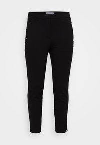 Pantalon noir ajusté en tissu doux, doté de deux poches avant avec des accents métalliques subtils, d'une conception de jambe fuselée et d'une texture lisse.