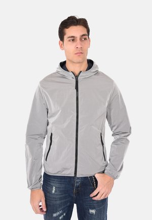 Giacca leggera grigia con cappuccio, zip frontale e due tasche laterali; realizzata in materiale liscio e resistente all'acqua con polsini elasticizzati.