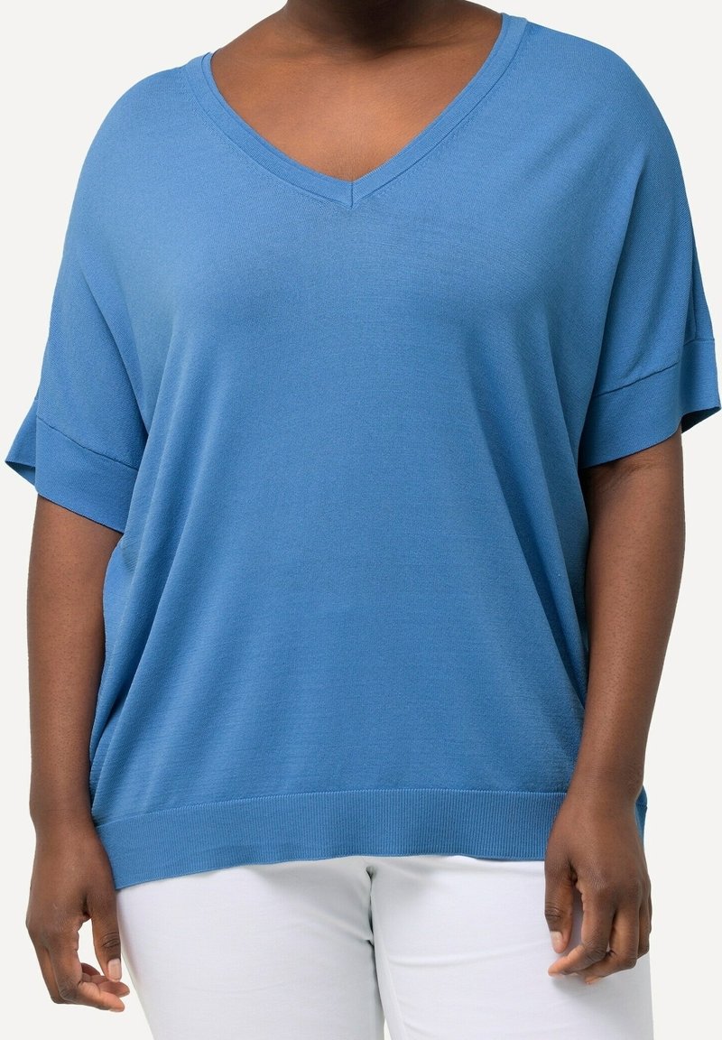 Överdimensionerad blå topp i bomullsblandning med V-hals, korta uppvikta ärmar och ribbad nederkant, med en avslappnad passform.