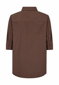 Chemise marron à manches longues avec un col classique, des poignets boutonnés et une texture lisse, offrant une coupe décontractée et un ourlet droit.