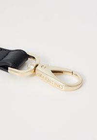 Fekete bőrszíj arany színű fém csattal. A csat a "Valentino" felirattal van domborítva. Simaságával és strukturált kialakításával tűnik ki.