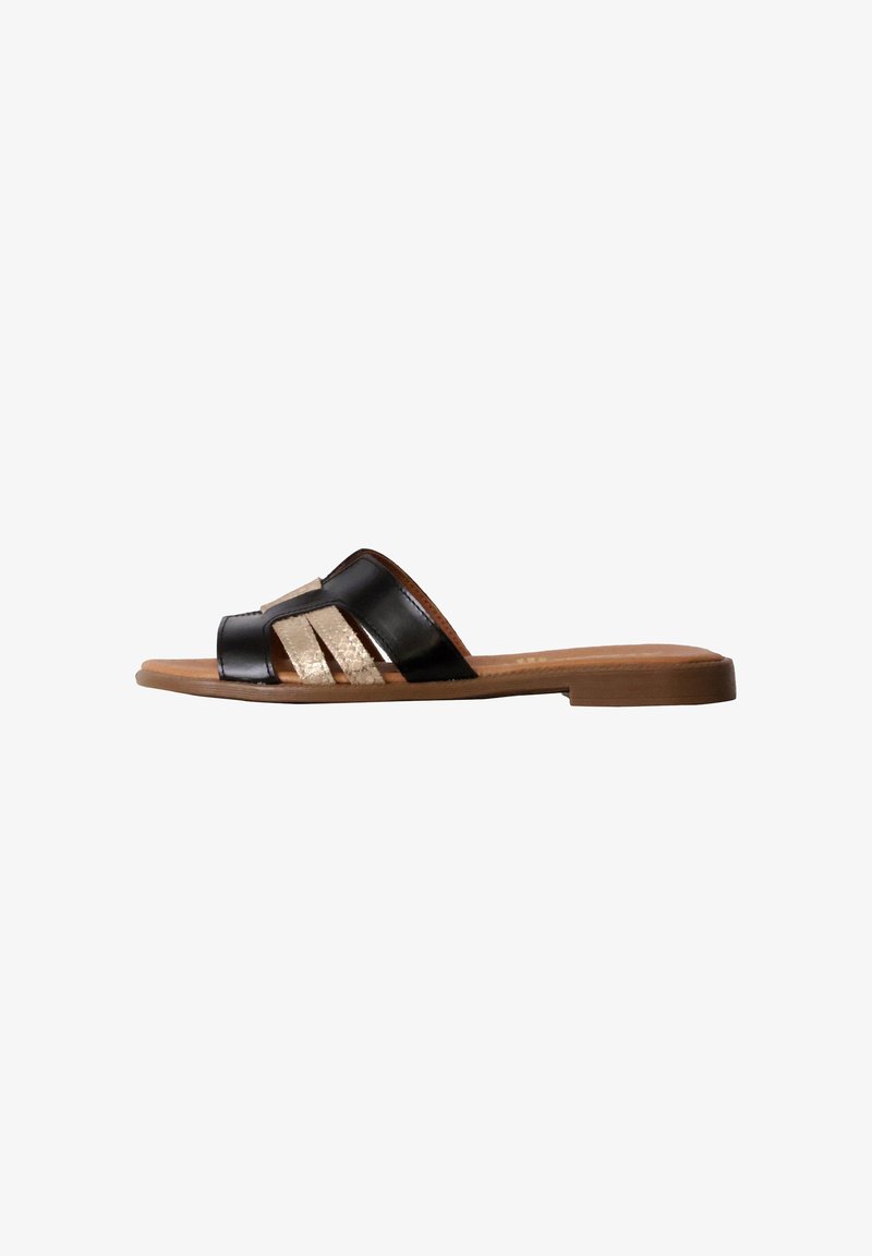 Sandale plate à enfiler avec des brides en cuir noir et beige et une semelle couleur cognac vue de profil sur fond blanc.