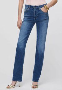 Sinised teksapüksid sirge lõikega, kõrge vöökohaga, pehme pleekimisega ja esitaskutega, mida on kombineeritud metallik-kuldsete kontsadega.