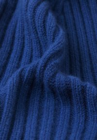 Blue knitted fabric with vertical ribbing texture; soft, warm, and slightly fuzzy appearance, showcasing deep color depth and light sheen.