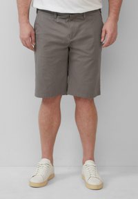 Grijze chino shorts met een rechte snit, gemaakt van een katoenmix. Bevat riemlussen en een ritssluiting. Gecombineerd met witte sneakers.