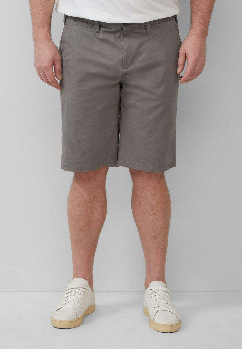 Grijze chino shorts met een rechte snit, gemaakt van een katoenmix. Bevat riemlussen en een ritssluiting. Gecombineerd met witte sneakers.