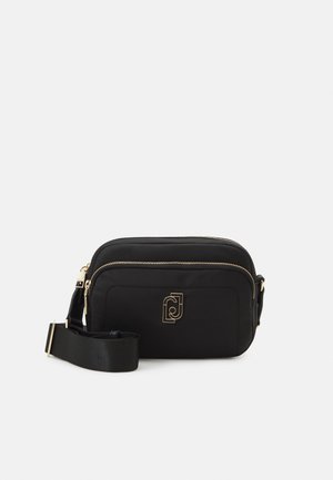 Black rectangular crossbody bag with gold zippers, front pocket, adjustable strap, and gold geometric logo on front.